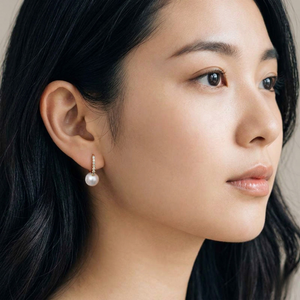 Close-up of a woman wearing pearl earrings with a neutral background-J.Collins Jewelry