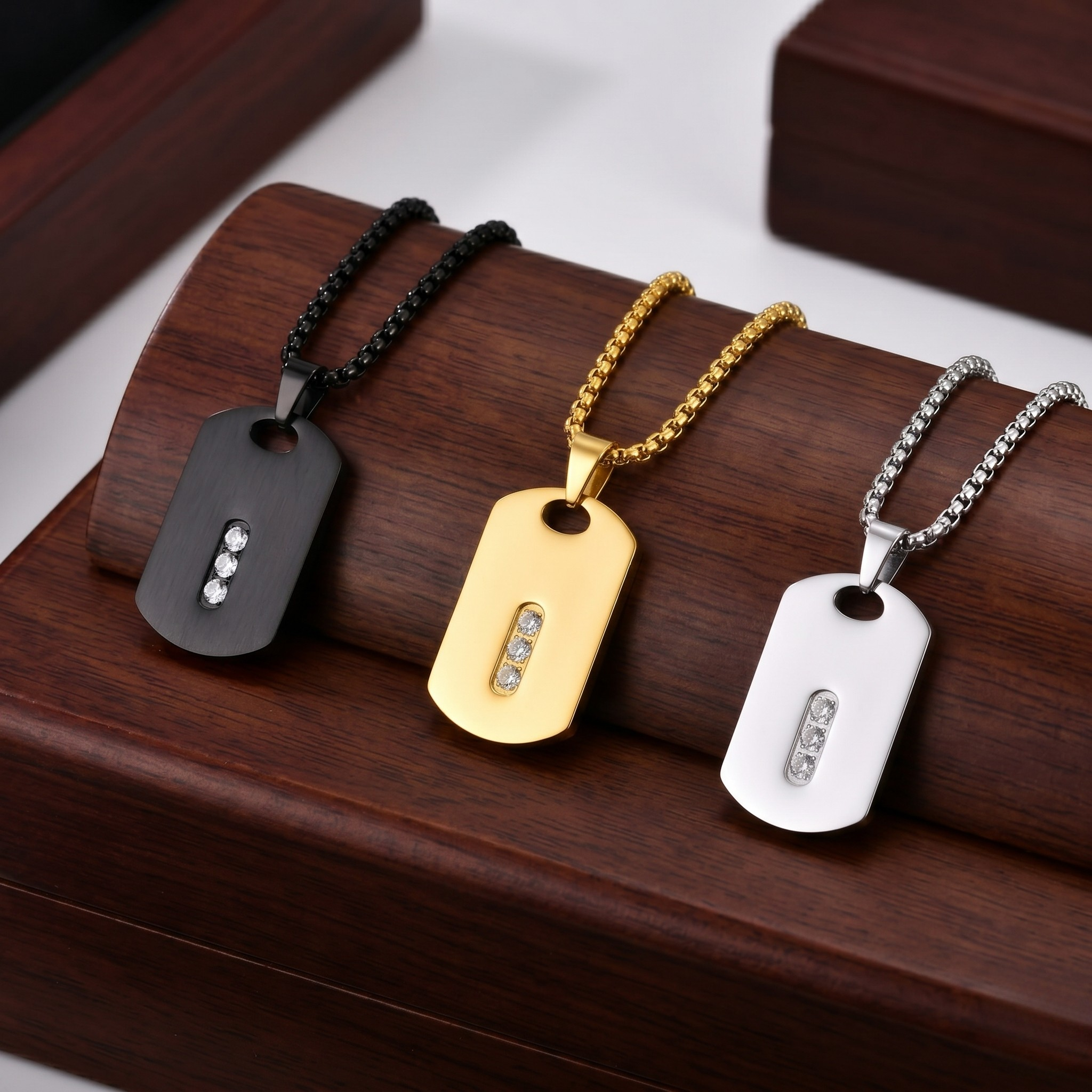 Three dog tag necklaces in black, gold, and silver on a wooden surface-J.Collins Jewelry