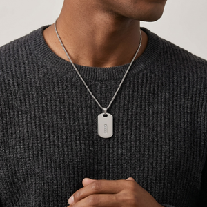 Person wearing a dark gray sweater with a silver necklace featuring a dog tag-J.Collins Jewelry