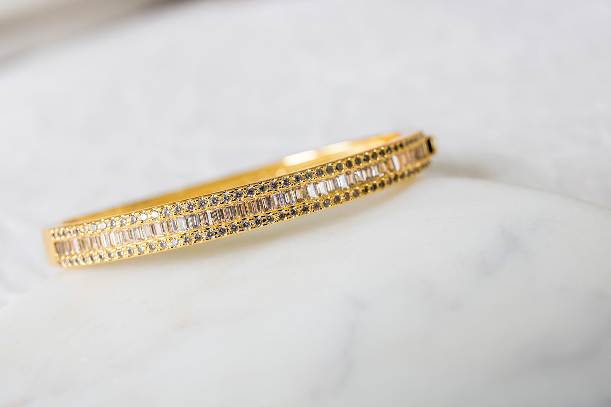 Gold bracelet with embedded stones on a light background-Lustre-Line-Cuff-J.Collins Jewelry
