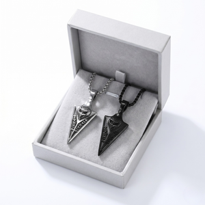 Nordic totem pendants in silver and black metal on chains, displayed in a gray jewelry box.
