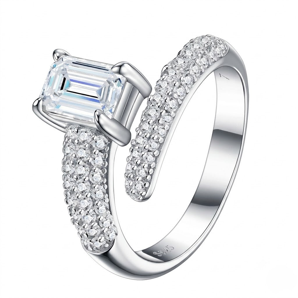A silver-toned split-shank ring featuring a large rectangular baguette-cut clear center stone and pavé-set clear stones along both split bands, shown on a plain white background - J.Collins Jewelry