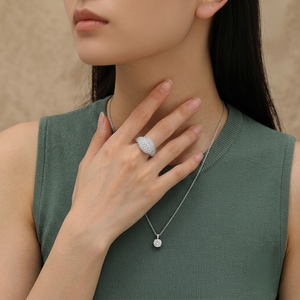 Sterling silver pavé dome signet ring and matching pendant necklace worn on hand and neck by model wearing a sage green sleeveless top by J.Collins
