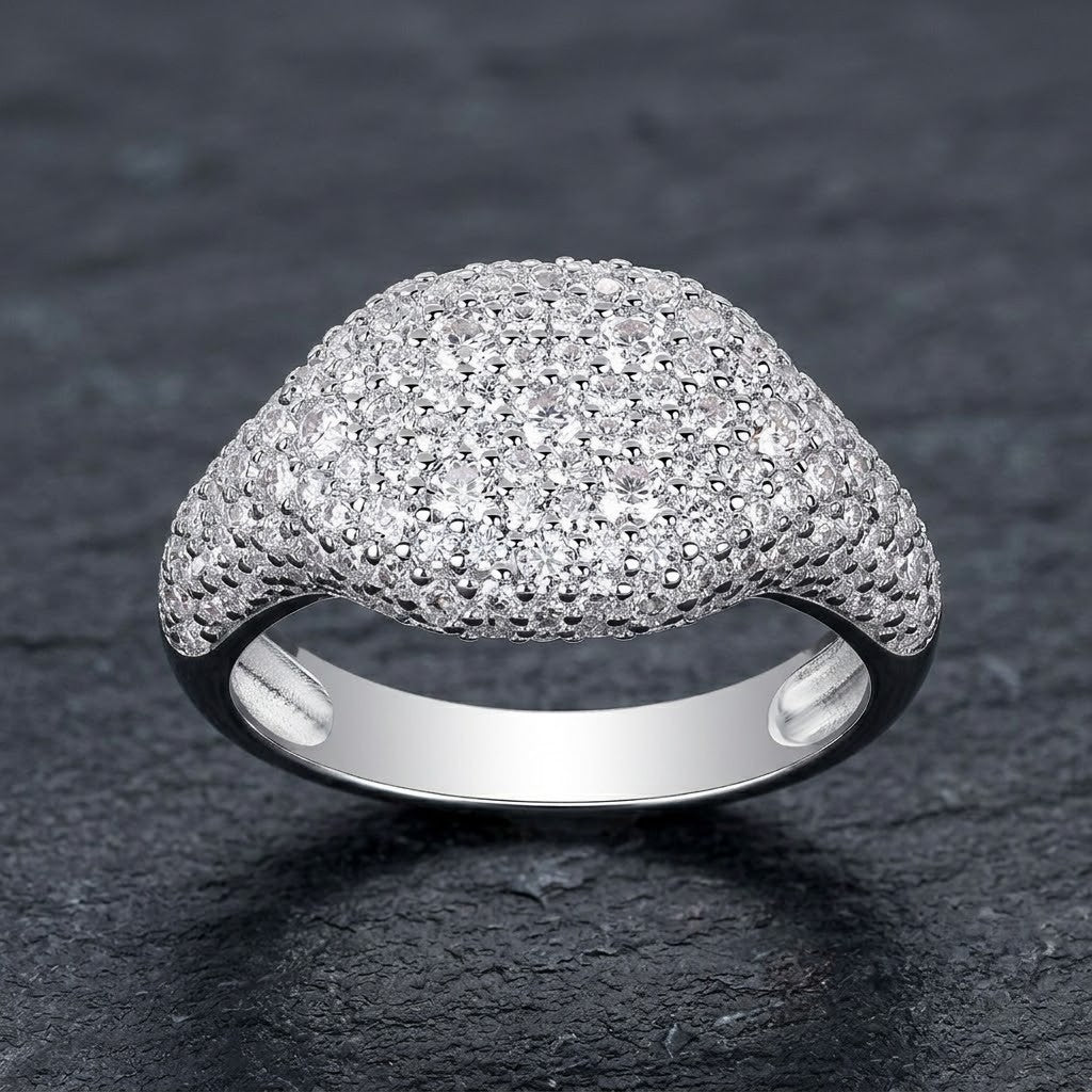 Sterling silver pavé dome signet ring fully encrusted with micro-paved cubic Moissanite crystals displayed on a dark slate stone surface by J.Collins
