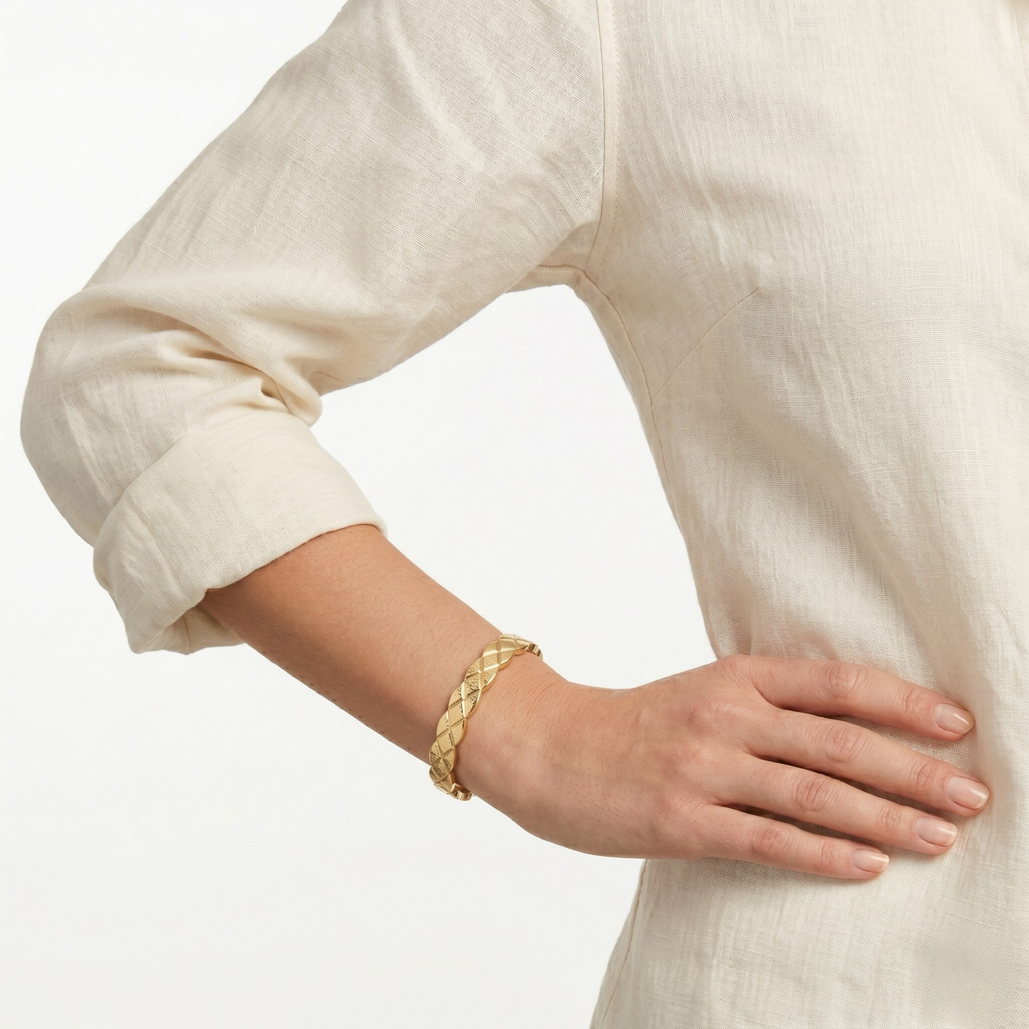 Gold bracelet on a wrist with a neutral background-J.Collins Jewelry