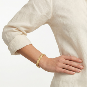 Gold bracelet on a wrist with a neutral background-J.Collins Jewelry
