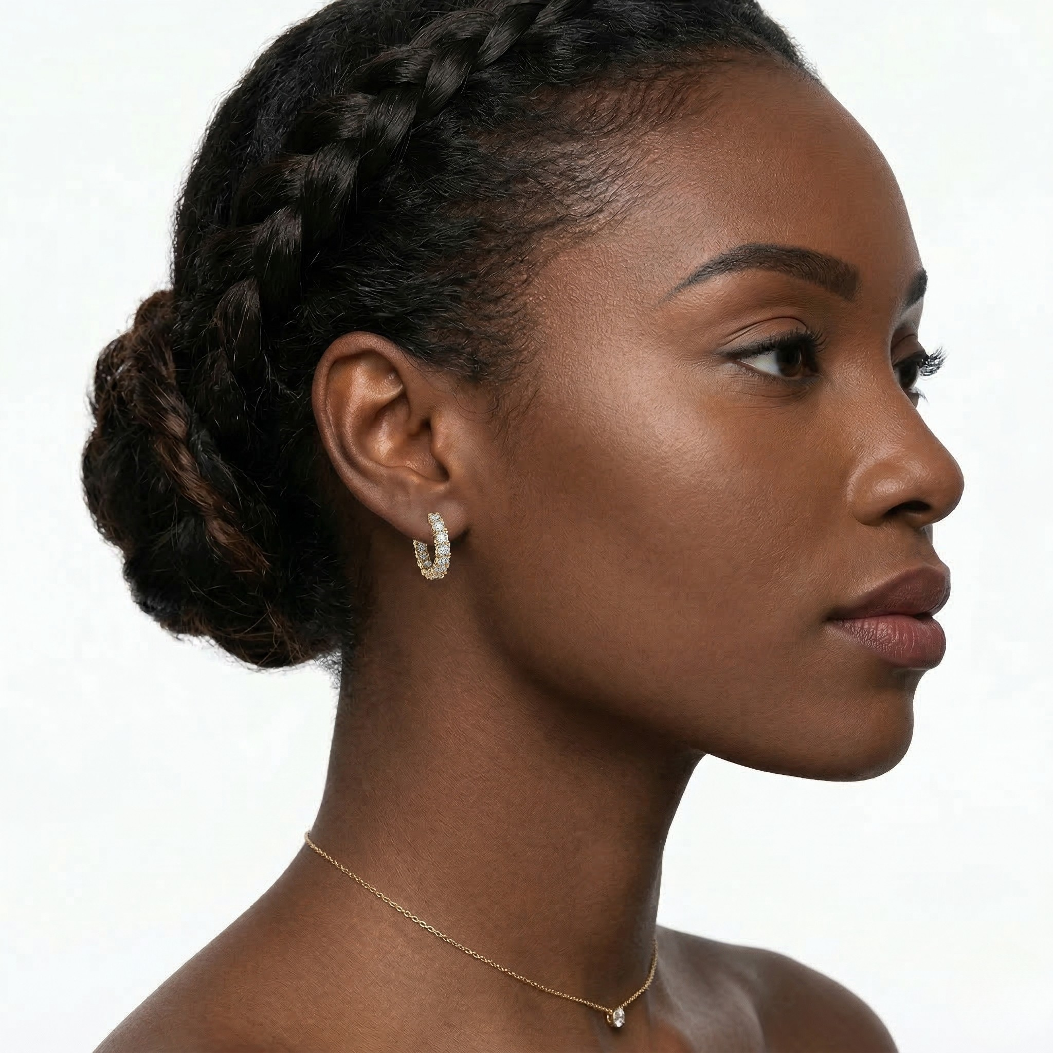 Woman with braided hair wearing a gold necklace and hoop earrings on a white background-J.Collins Jewelry
