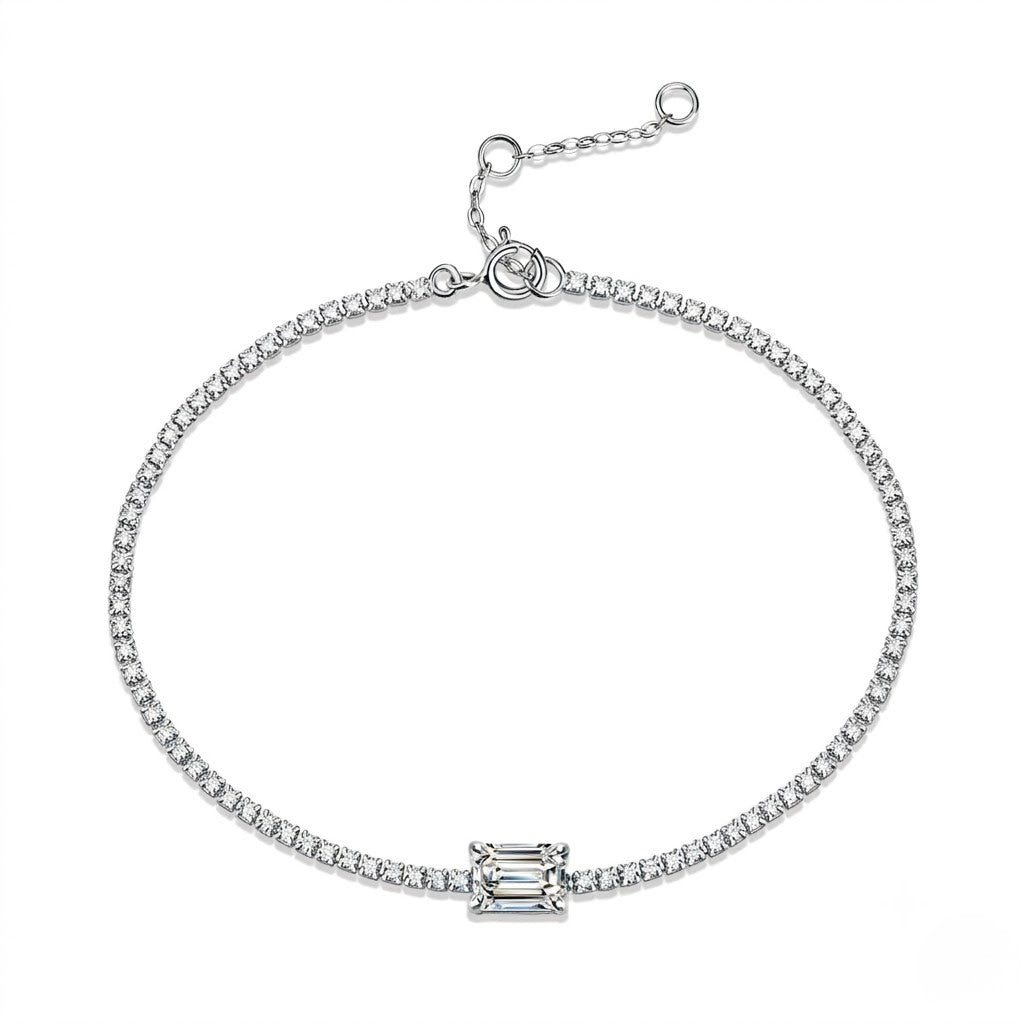 A white gold chain bracelet with a central rectangular baguette-cut clear gemstone, displayed on a clean white background - J.Collins Jewelry