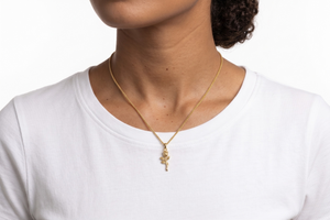 Person wearing a gold necklace with a small pendant on a white background- J.Collins Jewelry