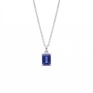 Silver emerald cut blue sapphire solitaire pendant necklace with four-prong setting on silver cable chain, white background - Sapphire Pendant Necklace - J. Collins Jewelry