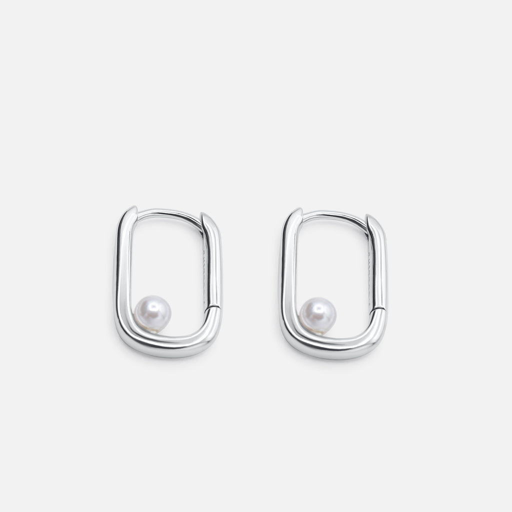 Pair of silver hoop earrings with pearl centers on a light gray background - Selene Pearl Hoops - JCollins Jewelry 
