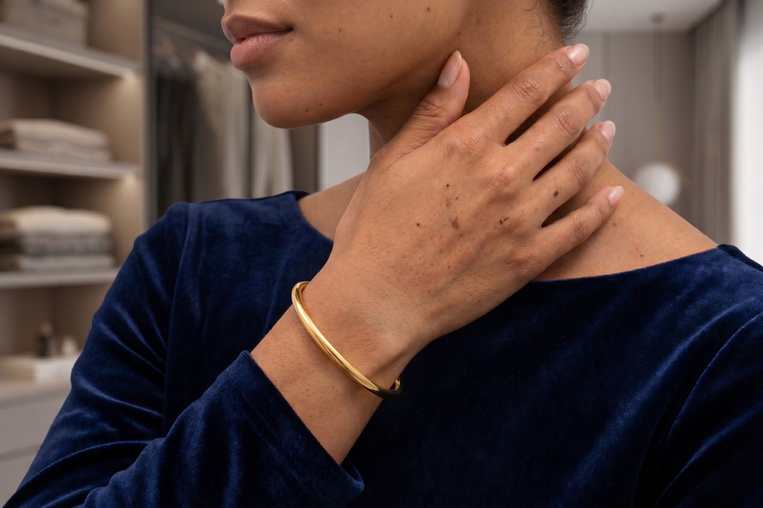 Person wearing a gold bracelet on a blurred background-J.Collins Jewelry