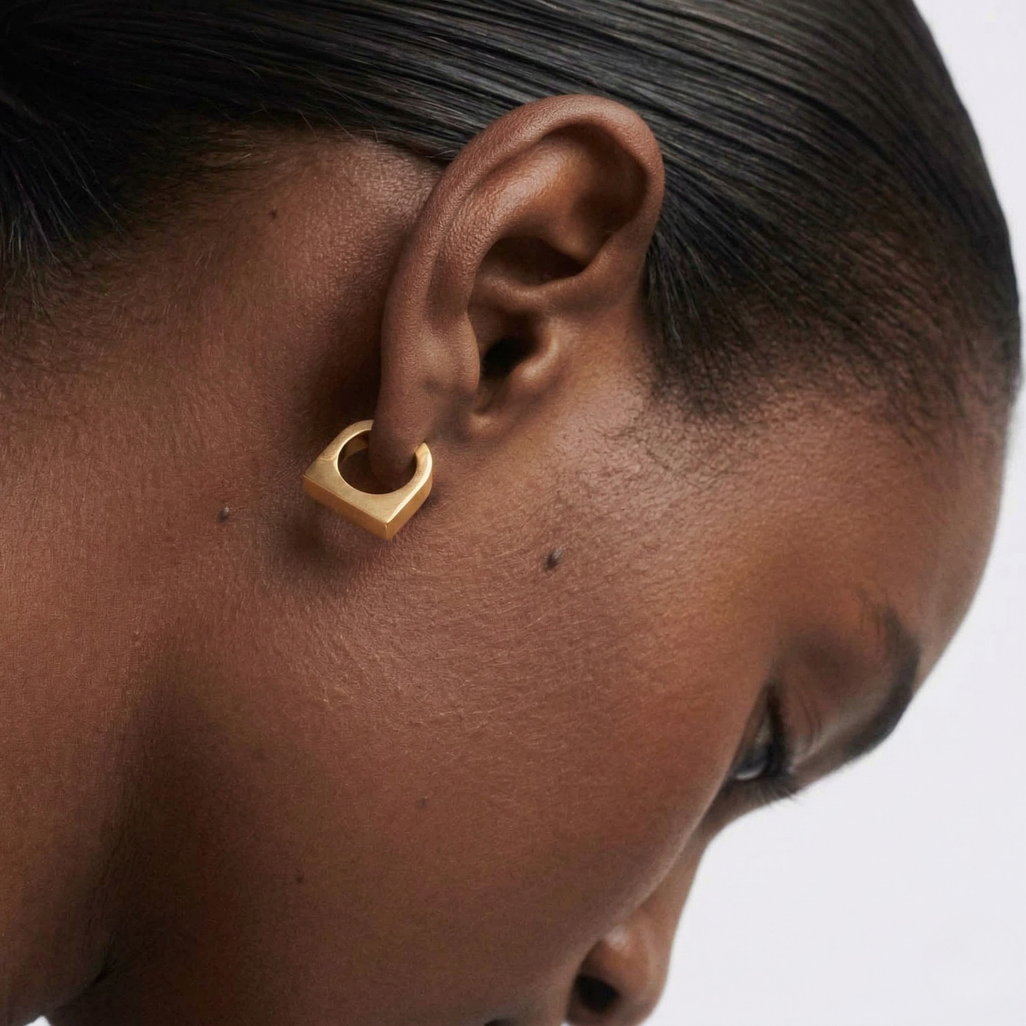 Woman wearing gold hoop earrings on a white background-J.Collins Jewelry