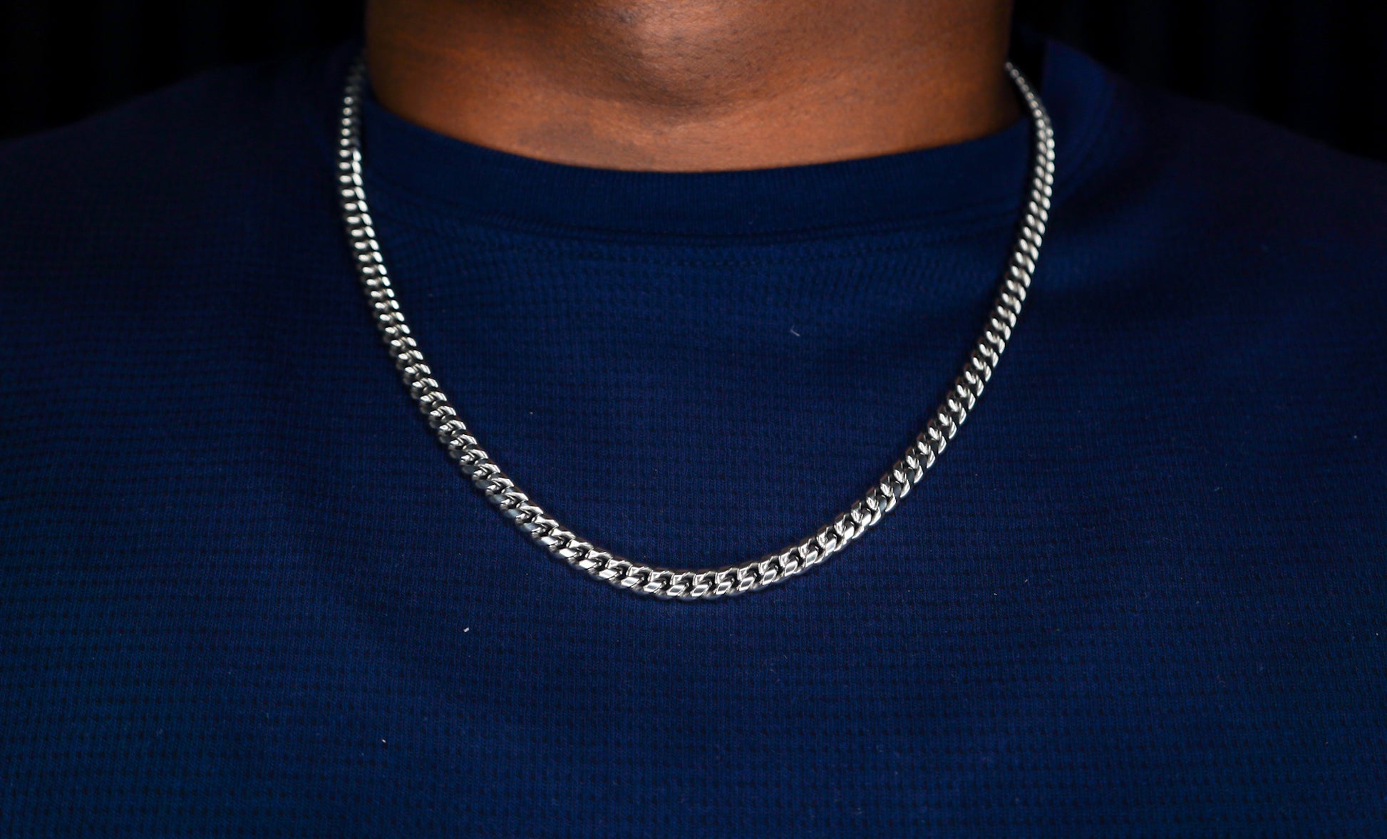 Silver chain necklace on a person wearing a dark blue shirt-Iconic-Cuban-Chain-JCollins-Jewelry