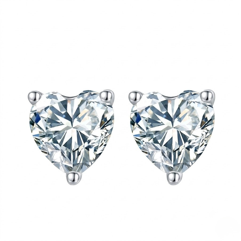 A pair of heart-shaped diamond stud earrings in a silver four-prong setting, shown against a plain white background. J.Collins Jewelry 