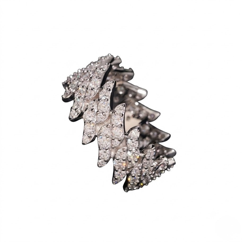 A white gold ring featuring a layered, wavy design paved with clear cubic zirconia stones, set against a plain white background - J.Collins