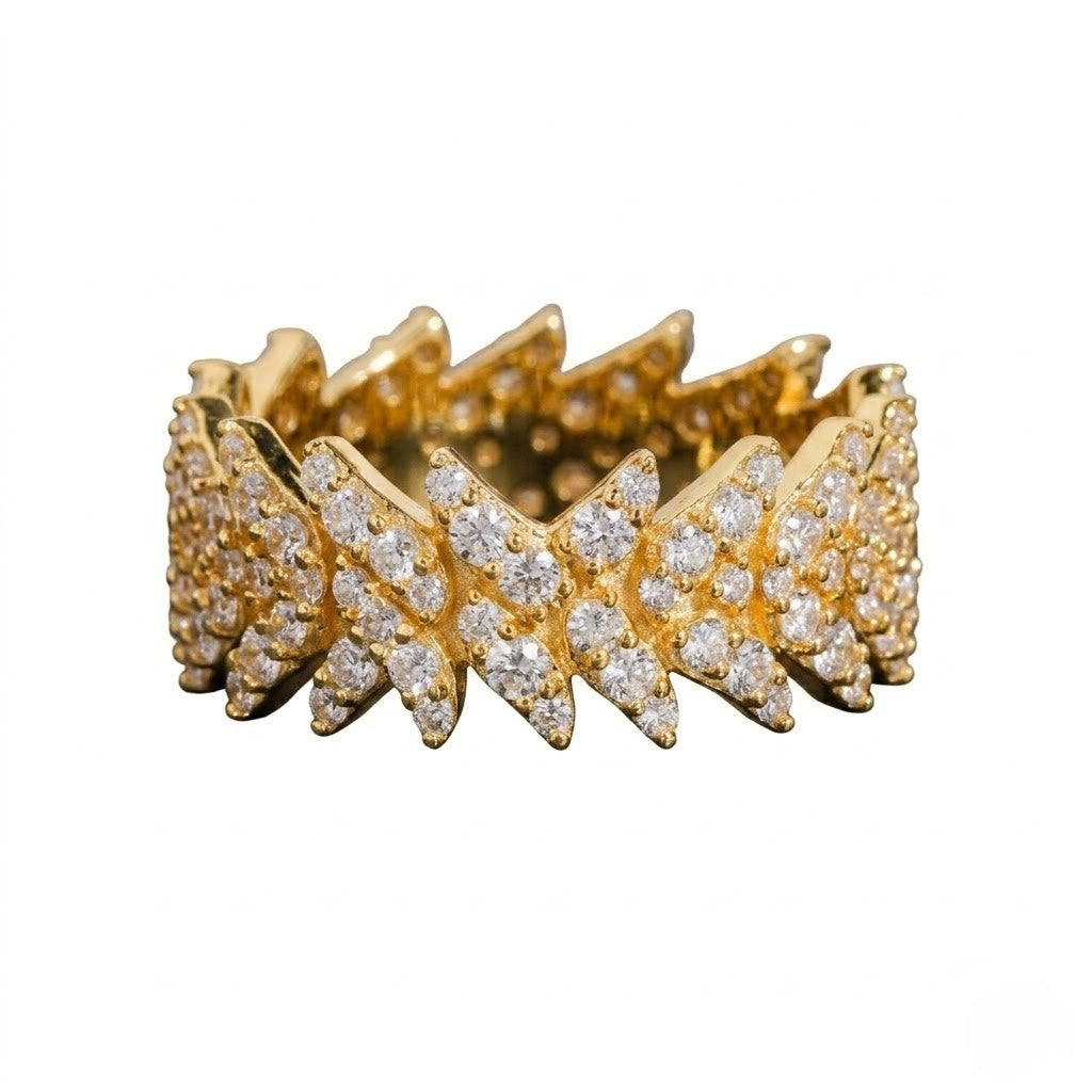 A gold band ring featuring a wide, jagged chevron pattern paved with clear round gemstones, shown against a plain white background - J.Collins Jewelry