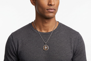 Man wearing a dark gray shirt with a necklace featuring a compass pendant on a white background-J.Collins Jewelry