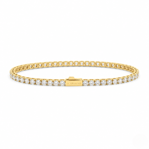 A gold tennis bracelet with round-cut clear stones, featuring a central clasp engraved with 'J.COLLINS', set against a plain white background - J.Collins Jewelry