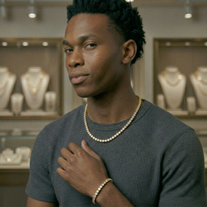 Man wearing a gold tennis necklace and a tennis chain bracelet in a jewelry store-Tennis Chain 5mm (Gold) by J.Collins Jewelry 