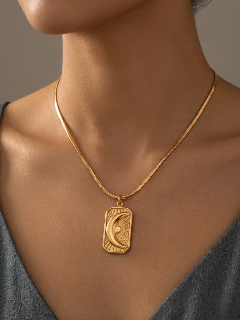 Gold medallion necklace featuring a crescent moon design, worn by a model with a neutral background.
