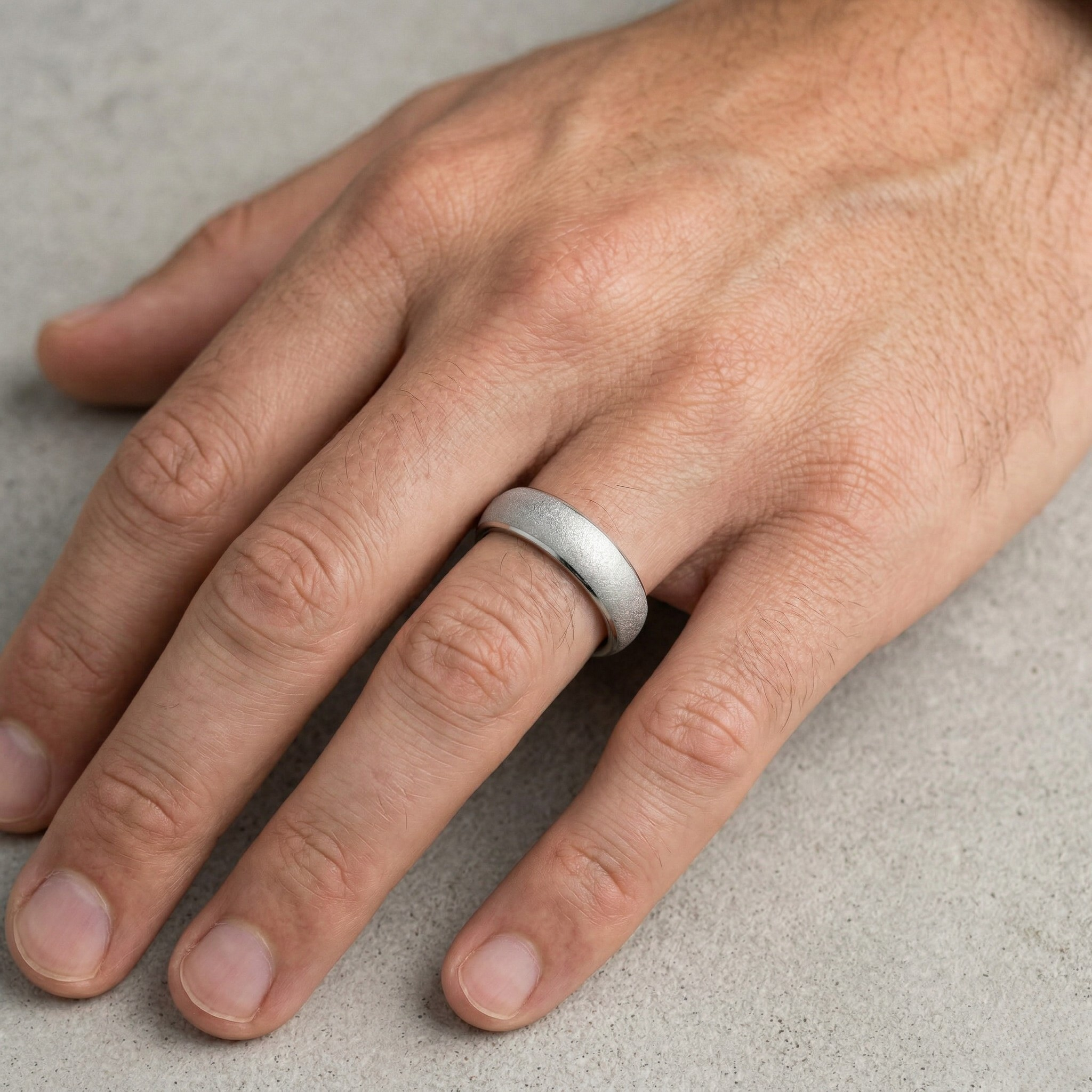 Hand wearing a silver ring on a neutral background- J.Collins Jewelry