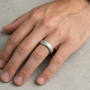 Hand wearing a silver ring on a neutral background- J.Collins Jewelry