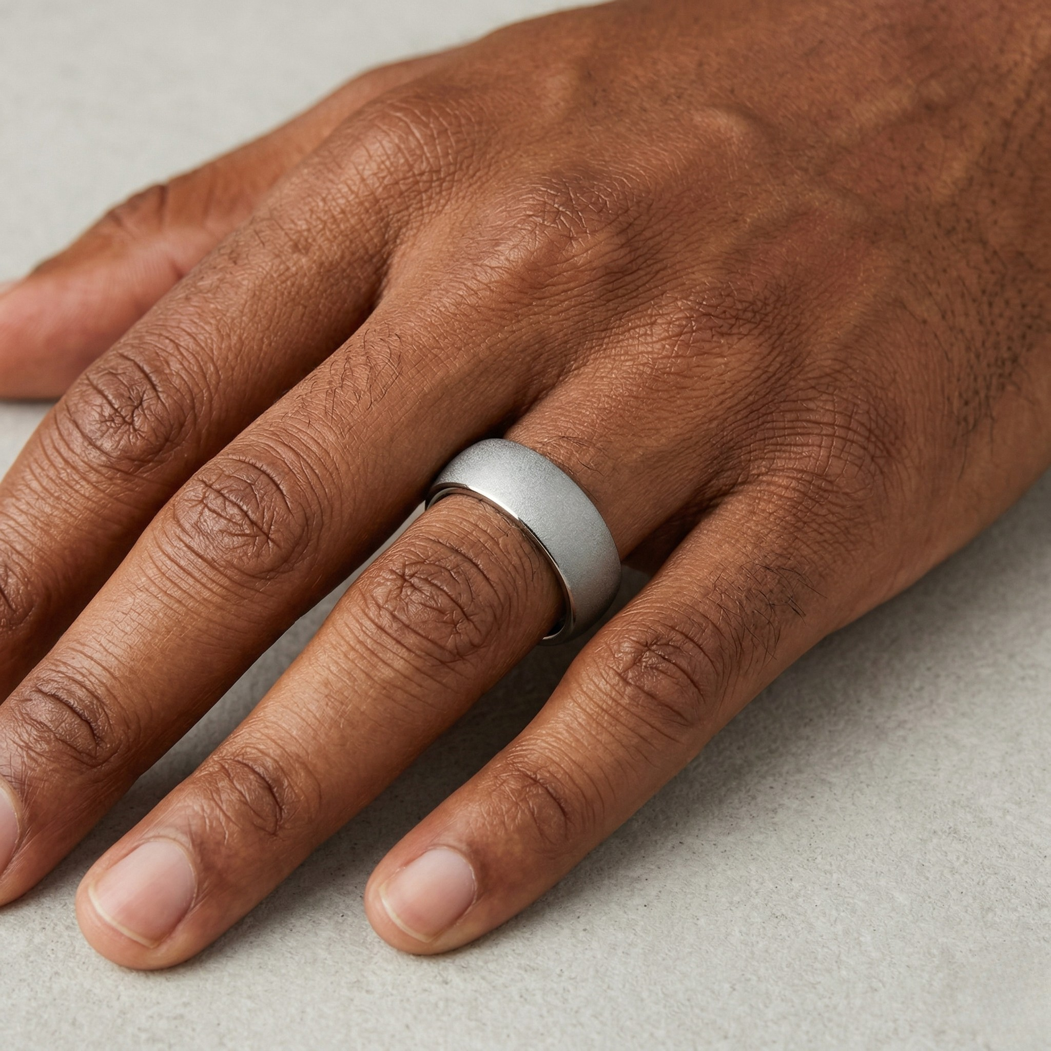 Hand wearing a silver ring on a neutral background- J.Collins Jewelry