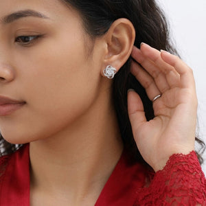 Woman wearing sterling silver interlocking love knot stud earrings with sparkling CZ halo - J.Collins Jewelry