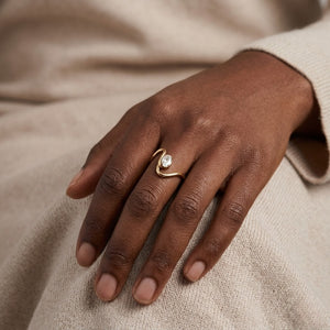 Model  wearing a modern gold wave ring with a delicate oval diamond solitaire stone | J.Collins Jewelry