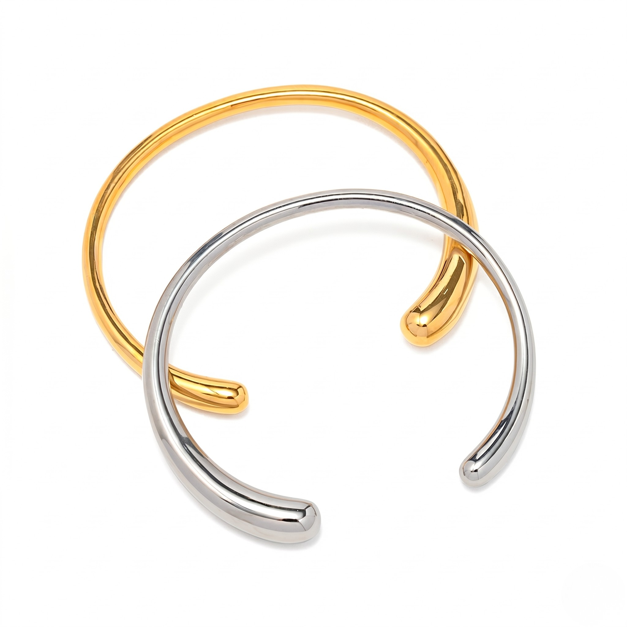 Gold and silver-toned open cuff bracelets, simple and elegant design, shown together.