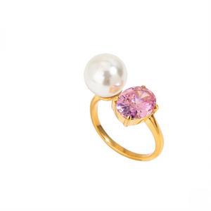 Gold ring with a white pearl and pink gemstone on a white background