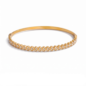 Gold-tone stainless steel bangle with a cluster design featuring small sparkling stones.