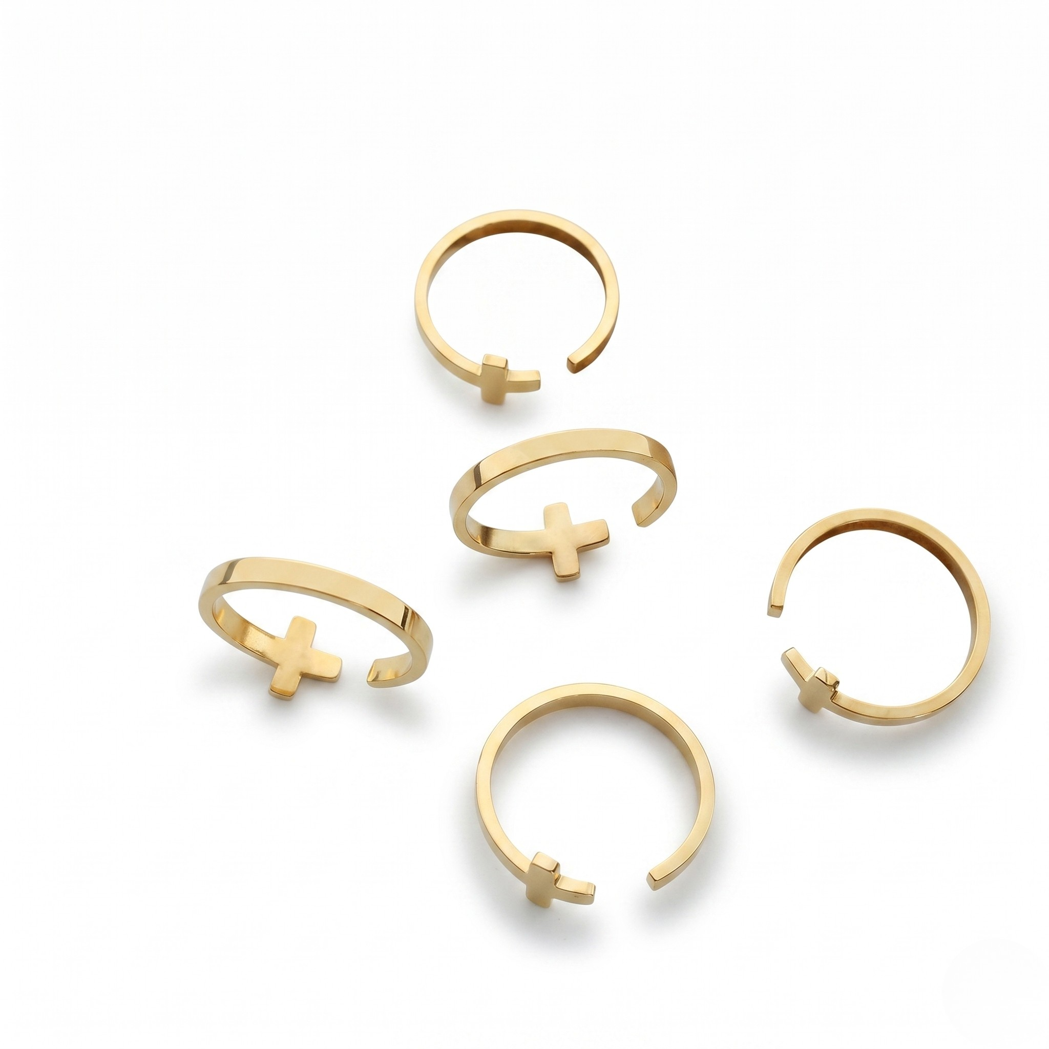 Gold open-band rings with minimalist cross design, set of five on white background