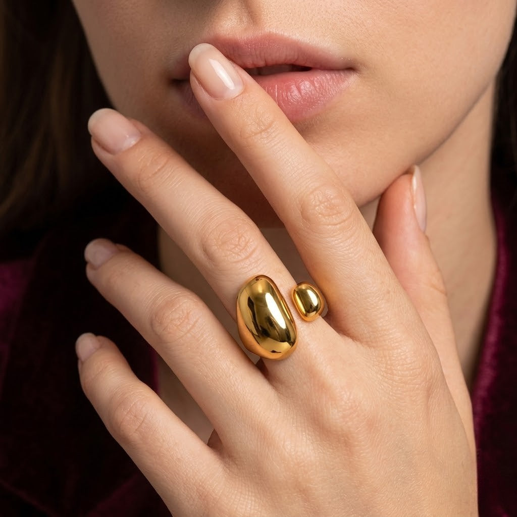 Gold Dune Open Ring with two polished beads worn on a woman's hand with manicured nails.