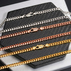 Miami Cuban Link Necklace 5mm in silver, rose gold, and gold on a dark textured surface