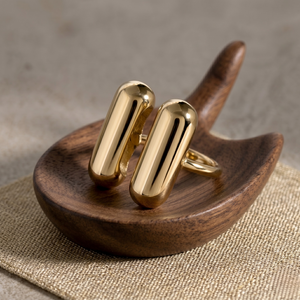 Twin Bar Ring in gold displayed on a wooden holder, showcasing sleek and modern design.