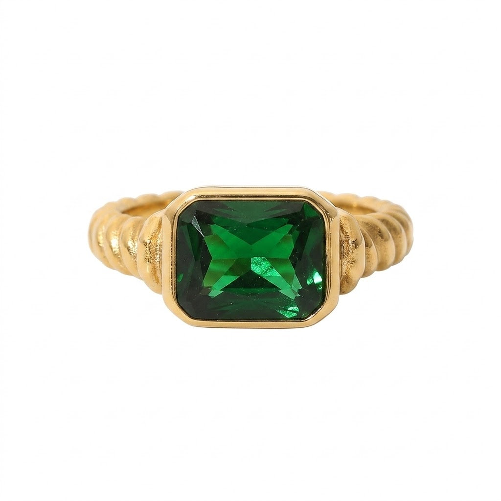 Gold ring with green square-cut gemstone and textured band.