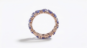 14K rose gold eternity band with round lab-created sapphires
